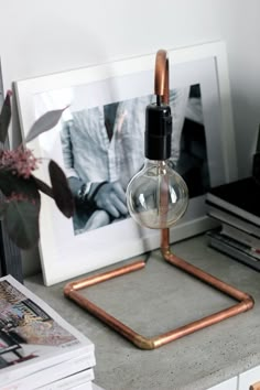 a lamp that is sitting on top of a desk next to some books and pictures