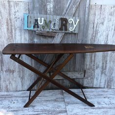 a wooden bench sitting in front of a wall with the word laundry on it's side