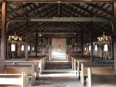 the inside of an old church with pews and flowers in vases hanging from the ceiling