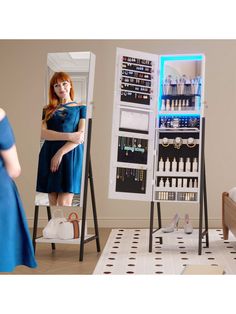 a woman in a blue dress is looking at herself in the mirror