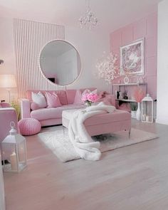 a living room filled with pink furniture and flowers in vases on top of a table