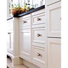 a kitchen with white cabinets and black counter tops