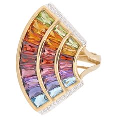 14 karat yellow gold multicolour rainbow contemporary wing cocktail ring This multicolour rainbow natural gemstones single wing ring, a mesmerizing blend of grace and vibrancy. Crafted in elegant 14k gold, this ring feature a distinctive three-line design that exudes contemporary sophistication. The wing of this ring showcase a dynamic arrangement of six different gemstones—peridot, citrine, garnet, rhodolite, amethyst, and blue topaz. Each gemstone, meticulously fancy cut, is channel-set to create a seamless flow of colors. As you move up each line, the size of the gemstones gracefully increases, adding a captivating sense of movement and dimension to the design. The diamonds on both sides enhance the overall brilliance of the ring, creating a harmonious balance with the colorful gemstone Rainbow Cocktail, Wing Ring, The Wing, Channel Set, Topaz Gemstone, Cocktail Ring, Line Design, Cocktail Rings, Gemstone Colors