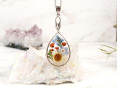 "This listing is for a lightweight lovely botanical necklace of a bouquet of flowers in jeweler's grade eco resin. All flowers have been carefully placed in hand poured resin, done in many steps, to give this a colorful, natural garden appearance. This Elegant Pendant will make an Eye Catching Accessory for Any Outfit Teardrop silver-tone bezel frame nickel and lead-free - measures about 1 1/4 \" x 7/8\" (about 34x21 mm), comes with Hypoallergenic surgical steel chain Teardrop Sterling Silver fr Botanical Flower Necklace For Mother's Day, Mother's Day Botanical Flower Jewelry, Delicate Spring Jewelry Gift, Delicate Flower Necklaces For Spring, Delicate Flower Necklace For Spring, Delicate Spring Jewelry For Gift, Nickel-free Flower Necklace For Mom, Nickel-free Flower Necklace As Gift For Mom, Mother's Day Flower Necklace With Pressed Flowers