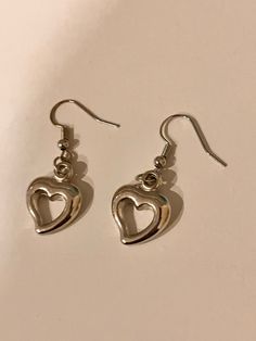 Adorable silver dangly heart earrings. cute y2k themed aesthetic earrings. Trendy Single Heart Earring, Trendy Single Heart-shaped Earring, Trendy Dangle Heart Earrings, Trendy Dangle Heart Earrings For Pierced Ears, Trendy Everyday Heart Dangle Earrings, Trendy Pierced Heart Dangle Earrings, Trendy Double Heart Pierced Earrings, Trendy Dangle Heart Earrings With Ear Wire, Trendy Heart-shaped Earrings With Heart Charm