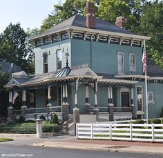 a large blue house sitting on the side of a road