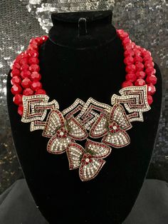 "Heidi Daus Gotta Have It Crystal Accented Red Beaded Necklace Celebrate your unbirthday with this party-perfect piece. Bold red beads and a crystal-loaded floral drop bring a refreshing quality to your favorite looks. At a women's luncheon, a quaint tea party or an elegant evening for two, this garden fresh look is sure to impress. Crystal Information This piece was made from CRYSTALLIZED™ - Swarovski Elements This piece contains Clear & Siam-color crystals Design Information Three rows of Elegant Red Rhinestone Necklaces, Red Jeweled Crystal Necklace, Red Rhinestone Party Jewelry, Red Rhinestone Party Necklaces, Red Beaded Jewelry For Party, Red Gemstone Beads Necklace For Party, Red Glamorous Jewelry For Celebration, Glamorous Red Jewelry For Celebration, Jeweled Beaded Necklaces For Party