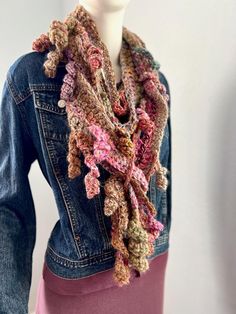 This Rosa scarf has the colors and textures of Fall.  It is a free-form crochet scarf made from various wool blends and synthetic yarns in a beautiful array of soft colors of pinks, beige, camel, greens, purples, rose, gold, and many more. There are lots of very soft hand-spun yarns in this scarf, making it ultra-soft.  There are various splits in the scarf pattern to allow you to pull ends through for more style possibilities.  The video shows how the random breaks in the pattern allow you to pull the scarf through for more styling possibilities.  It is about 72 inches long/ and varies between 3,5-4.5  inches wide (varies throughout the scarf) and can be used to create many different looks.   NOTE: The 2024 scarf collection celebrates remarkable women by naming each scarf after a specific Pink Shawl Scarves For Fall, Pink Shawl Scarf For Fall, Pink Shawl For Fall, Bohemian Knitted Scarves For Fall, Bohemian Yarn Scarves For Fall, Bohemian Knit Scarves For Fall, Pink Bohemian Scarf One Size, Pink Bohemian Scarves For Fall, Pink Bohemian Scarf For Fall