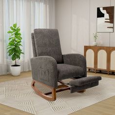 a living room with a rocking chair and footstool next to a potted plant