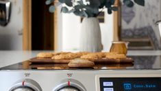 an appliance with cookies on the burner in a kitchen area next to a potted plant