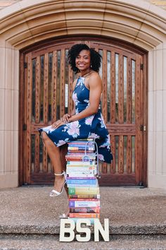 a woman sitting on top of a stack of books with the words bsn in front of her