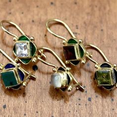 Cast your own light from the shadows in these cubic zirconia and green enamel earrings. 24k gold over sterling silver with hinged backs. Size: 3/4 Inch. 14k Gold Hinged Earrings As A Gift, Classic Green Enamel Jewelry, Gold Hinged Earrings As A Gift, Gold Hinged Earrings For Gift, 14k Gold Hinged Jewelry For Gifts, Green Enamel Jewelry With Gemstones, Fine Jewelry Hinged Gift, Gold Enamel Earrings With Gemstone, Forest Earrings