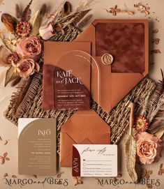 the wedding stationery is laid out with flowers, feathers and other things to put on it