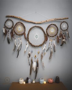 there is a wall hanging made out of different types of dream catchers and feathers