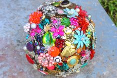 a colorful brooch sitting on top of a cement slab