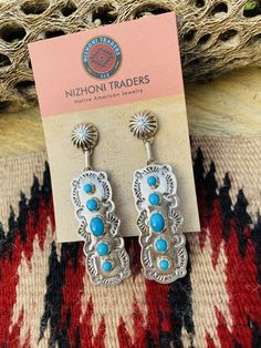 New without tags BRAND : Nizhoni Traders LLC ETHNIC & REGIONAL STYLE : Native American JEWELRY TYPE : Earrings METAL : Sterling Silver TRIBAL AFFILIATION : Navajo MAIN STONE : Turquoise Lovely Navajo Turquoise and Sterling Silver dangle earrings. Measure 2 7/8 inches long and 3/4 of an inch wide. Great pair of earrings! Stamped Sterling and signed by the artist. Thank you for checking out my store. Please contact me with any questions. Exported By exportyourstore.com Southwestern Style Blue Pierced Earrings, Southwestern Style Blue Earrings For Pierced Ears, Southwestern Blue Earrings For Pierced Ears, Artisan Blue Drop Earrings, Southwestern Style Blue Drop Earrings, Southwestern Blue Drop Earrings, Southwestern Blue Earrings For Gift, Blue Southwestern Style Earrings For Gift, Navajo Turquoise