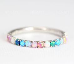 Exclusive to Benati Bridal. Half eternity wedding band set with multi color lab opal band. A symbol of ever lasting love - a perfect wedding or promise opal ring. Beautiful feminine opal eternity promise ring - a symbol of pure love! Beautifully set with rainbow lab opals. Opals go HALF way around the band. Total approx. width of ring: 2 mm. Size of stones: 2mm Select your gold of choice - 14k/18k solid white / yellow / red (rose) gold. Made to a high polish, top craftsmanship. Comfortable and s Mothers Rings, Opal Wedding Band, Elegant Wedding Rings, Wedding Band For Women, Rainbow Ring, Opal Band, Half Eternity Wedding Band, Rainbow Rings, Color Lab