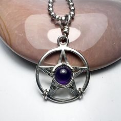 PENTACLE, MAGICKAL,7MM, amethyst 22mm Diameter, Pentagram, Sterling Silver, Magic,  Bruce designed this sterling silver pentacle to last a lifetime. I designed it in the 1980s. I sent the design to my friend Vicki  in Thailand. She made a cast of my design and cast it into silver. this particular pendant was cast in Thailand. I soldered on the bail and my daughter, Jamie, set the stone with sterling silver wire. . The size is about 7/8"(22MM) tall, not including the bail. The pendant has a mirror finish on both sides. It is smooth and gentle to the touch. I am including a stainless steel chain. Please select your preferred length. The pentacle is an ancient revered symbol. It represents the four elements (fire, water, air, earth) and spirit. The circle represents the universe. Thank you fo Mystical Silver Star-shaped Jewelry, Mystical Silver Star Jewelry, Silver Star Of David Necklace With Gemstone, Symbolic Amethyst Purple Jewelry, Purple Amethyst Symbolic Jewelry, Symbolic Purple Amethyst Jewelry, Mystical Silver Amethyst Necklaces, Spiritual Star-shaped Metal Jewelry, Mystical Silver Jewelry With Charms