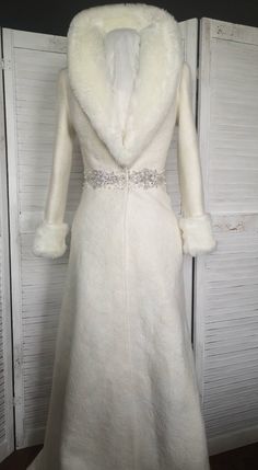 a white coat with fur collar and belt