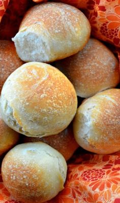 a basket filled with rolls covered in powdered sugar on top of a wooden table