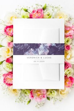 the wedding stationery is surrounded by flowers