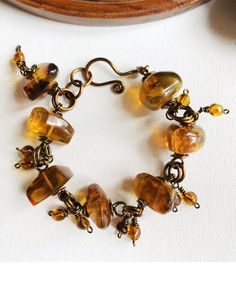 This Amber Rocks bracelet is such a warm combination of amber and antique brass finished wire. The natural Mexican Amber chunks gleam with rich russet colors paired with smaller amber dangles it makes the perfect statement bracelet. Luxury Amber Gold-plated Jewelry, Luxury Amber Gemstone Beads Jewelry, Expensive Decor, Amber Bracelet, Copper Bracelet, Amber Jewelry, Statement Bracelet, Neck Lace, Handmade Bracelet