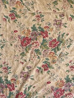 an old flowered fabric with red and pink flowers on it's side,