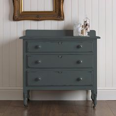 an old dresser is painted gray with gold trim and knobs on the bottom drawer