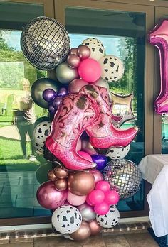 an elephant balloon sculpture is displayed in front of a window with balloons and other decorations