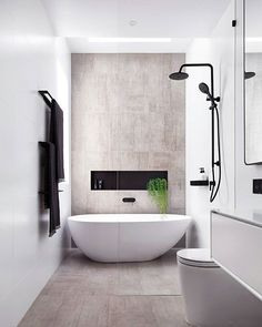 a bathroom with a white bathtub next to a toilet