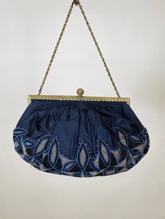 Antique Silk evening purse with French Steel-Cut Micro Glass Beads Purse in blue, silver, and black. The silk is in very good vintage condition, and the gold tone frame is detailed all around and works well. To open the purse tilt the filigree ball back and the closure will unlock. A beaded appliqué covers the majority of the purse, and the silk is gently gathered into the frame. On close inspection you can see some areas where the stitching was reinforced. This would be easy to remove or repair Blue Embroidered Formal Bag, Formal Blue Embroidered Bag, Blue Embellished Evening Bag For Formal Occasions, Embellished Blue Party Clutch, Blue Embellished Party Clutch, Formal Blue Embellished Evening Bag, Blue Beaded Clutch Evening Bag, Blue Beaded Evening Bag, Evening Blue Beaded Bag