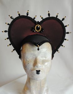 This vampire style gothic headdress is covered with taffeta and embellished with black breaded trimming all around the edges.It is further decorated with black beaded details that create a halo effect. The piece is completed with a black crystal handmade element placed at the center in order to create even more visual interest! Choose between burgundy (pictured), black or dark blue as well as having total black crystal beading or a combination of black crystals and golden pearls (pictured). The Medieval Masquerade Mask For Halloween Cosplay, Black Gothic Festival Costume, Medieval Masquerade Mask For Halloween, Black Medieval Masquerade Mask For Fantasy Events, Black Medieval Costume Accessories For Costume Party, Medieval Black Masquerade Mask For Fantasy Events, Black Medieval Costume Accessories For Parties, Black Fantasy Costume Accessories For Theater, Halloween Cosplay Costume Accessories With Tall Crown