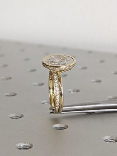 a diamond ring sitting on top of a piece of metal