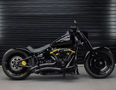 a black and yellow motorcycle parked in front of a garage door