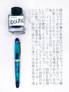 a fountain pen and ink on top of a piece of paper with writing in japanese