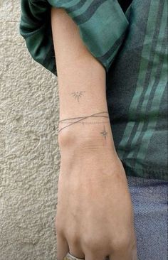 a person's arm with a small star tattoo on it