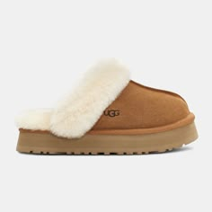 Merging the Coquette and Disco styles for a new slipper that's completely unique, the Disquette adds a 1" retro-style platform sole to a familiar slip-on silhouette for outdoor wear, all-day cushion, and a maximalist look. Crafted from UGG's signature sheepskin and suede, this effortless style adds a playful statement to all your favorite outfits – try pairing with jeans or a flowy midi dress. Suede upper Sheepskin collar 10mm sheepskin lining 10mm sheepskin insole EVA outsole Textile binding ma Ugg Platform Slippers, Expensive Christmas, Cute Uggs, Chestnut Uggs, Christmas Lists, Disco Style, Flowy Midi Dress, Inspo Fits, Ugg Slippers