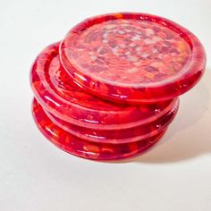 three red plastic plates stacked on top of each other, one is round and the other is small