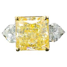 18kt white gold ring with diamonds Gold colour & karat: White gold 18kt Weight: 6.44 grams Set with- Stone type: Diamonds Shape: Radiant Carat: 6.13 ct Colour: Fancy Light Yellow Clarity: VS2 Surrounding Stones: Diamonds 1) Heart Diamonds Carat weight: 1.25 ct (02 pcs) Color: F Clarity: VS1/VS2 Cut: Heart Report type and Number: GIA 6224846884, GIA 5463837072, GIA 6485293776 Fancy Yellow Diamond Ring, Radiant Diamond Rings, Radiant Cut Diamond Ring, Yellow Diamonds Engagement, Canary Diamond, Cushion Diamond Ring, Yellow Diamond Engagement Ring, Yellow Diamond Ring, Cushion Cut Diamond Ring