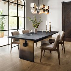 a dining room table with chairs and vases on it