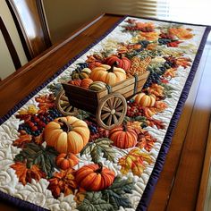 a table runner with pumpkins, gourds and a wagon on the table