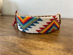 a colorful beaded bracelet sitting on top of a wooden table