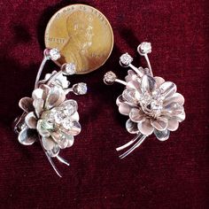 "A beautiful pair 1950's era clip-on earrings, a flower with rhinestones in silver tone. Well made with good tension on the backs, they are in good condition with some wear to silver on back, rhinestones are secure, MEASURES: 1- 1/8\"H Items are vintage, used NOT new or in perfect condition. PLEASE BE SURE TO REVIEW measurements, pictures, description & shop policies in full. I LOVE Etsy. My goal is to satisfy all of my customers, item is not in new condition, sales are final, I generally do Vintage Flower Shaped Clip-on Earrings, Vintage Flower Earrings For Anniversary, Vintage Clip-on Flower Earrings, Vintage Flower-shaped Earrings For Party, Vintage Flower Shaped Jewelry With Rhinestones, Vintage Flower-shaped Earrings For Anniversary, Vintage Flower-shaped Jewelry With Rhinestones, Vintage Flower Clip-on Earrings For Wedding, Silver Vintage Flower Earrings For Anniversary