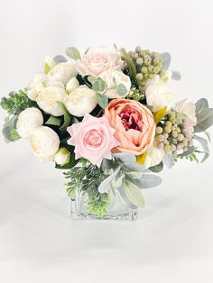 a vase filled with lots of flowers on top of a table