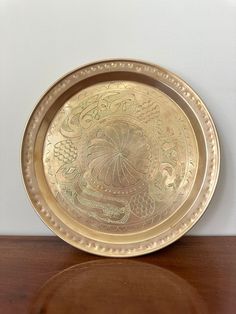 a gold plate sitting on top of a wooden table