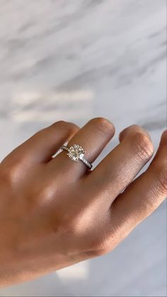 a woman's hand with a diamond ring on it