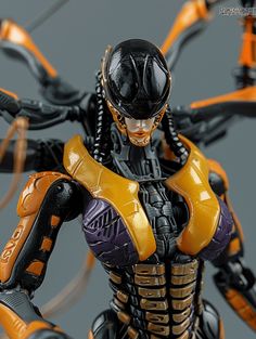 the action figure is wearing an orange and black outfit with yellow accents on his chest