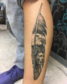 a man's leg with a tattoo on it that has an image of native americans