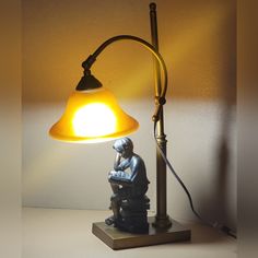 a lamp that is sitting on top of a wooden table next to a small figurine