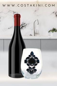 a wine glass and bottle sitting next to each other in front of a marble counter top